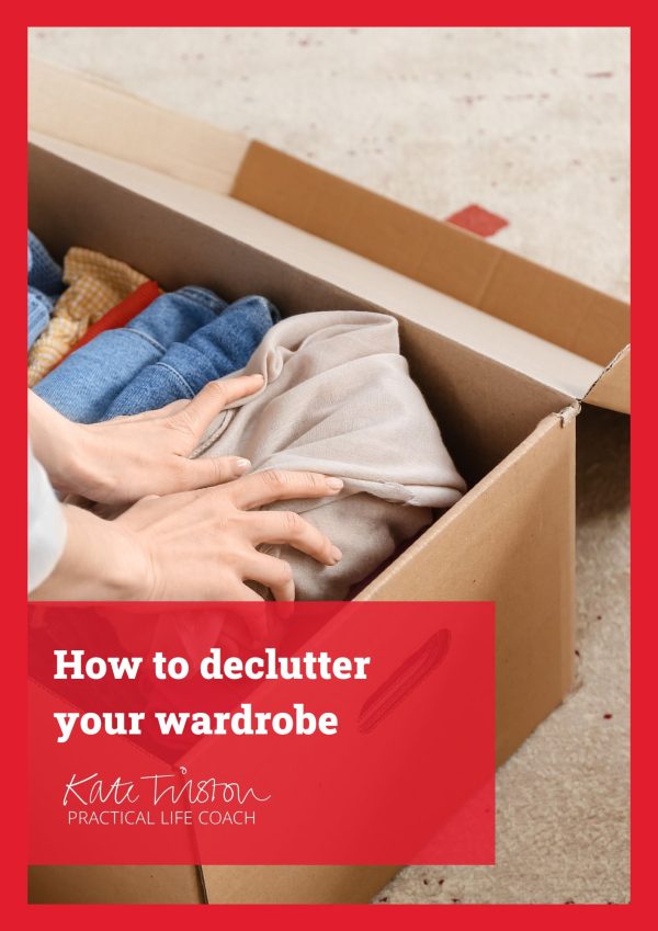 A woman organises clothes in a box to help her declutter her wardrobe